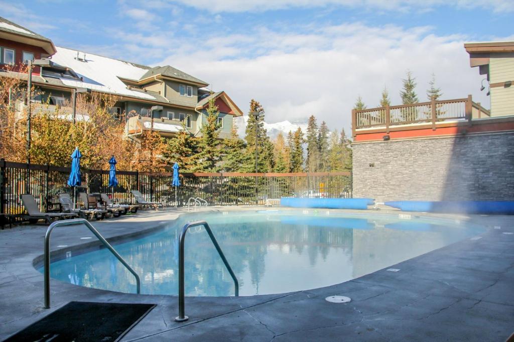 une grande piscine en face d'une maison dans l'établissement Fenwick Vacation Rentals Suites with Pool & Hot tubs, à Canmore