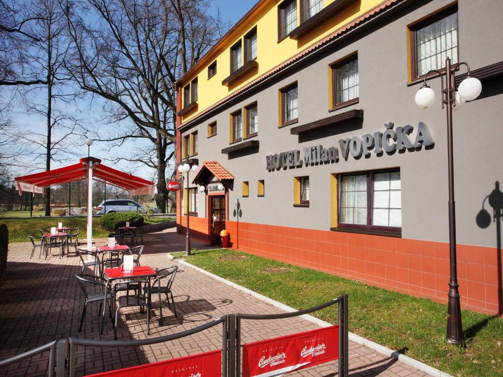 budynek ze stołami i krzesłami poza nim w obiekcie Hotel Milan Vopicka w mieście Hluboká nad Vltavou