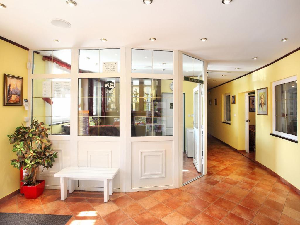 hol z białymi drzwiami i ławką w obiekcie Hotel Milan Vopicka w mieście Hluboká nad Vltavou