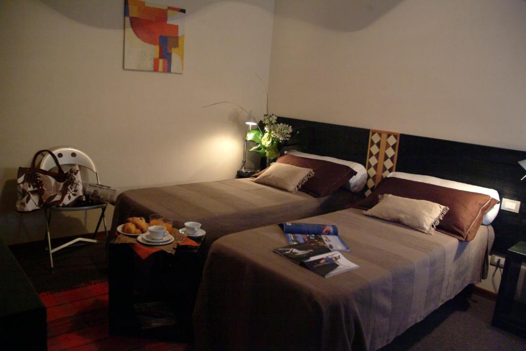 una camera d'albergo con due letti e un tavolo di Hotel Orvieto a Orvieto