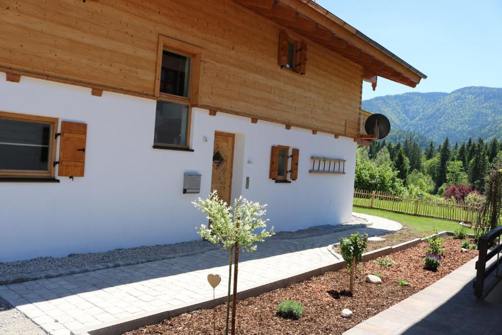 a house with a wooden roof at Chalet Steinplatte in Reit im Winkl