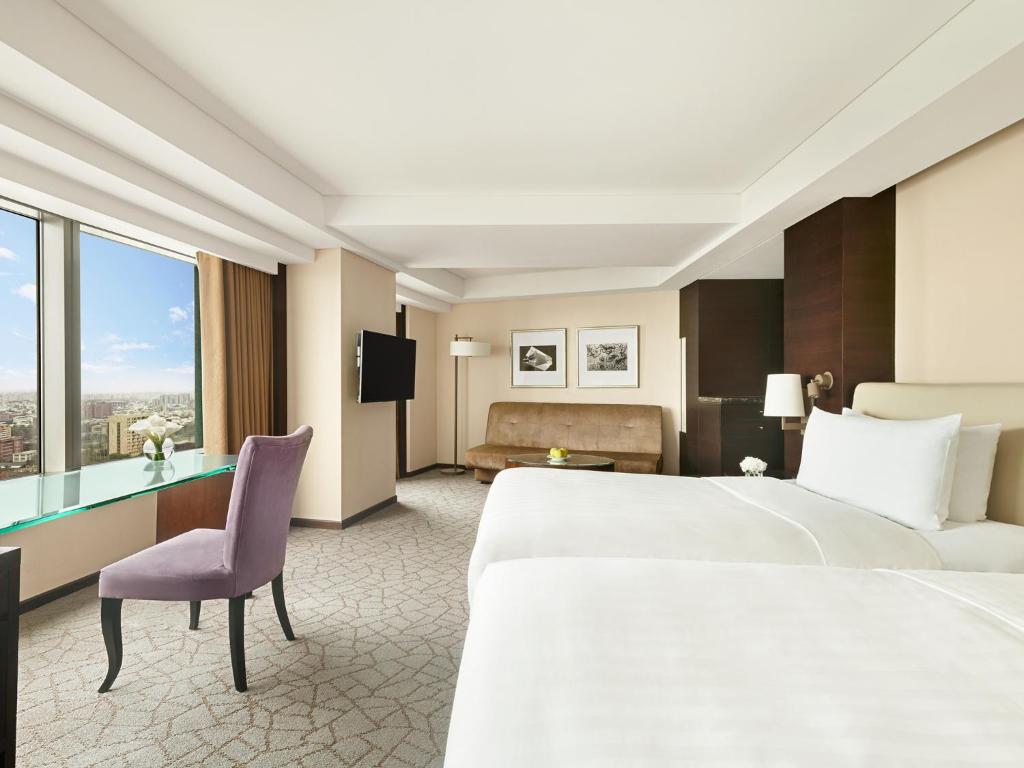 a hotel room with a bed and a desk at Shangri-La Far Eastern Tainan in Tainan