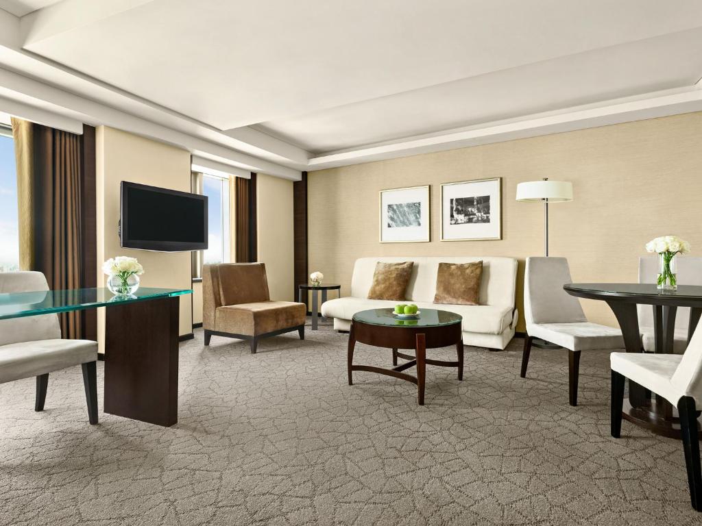 a living room with a couch and a tv at Shangri-La Far Eastern Tainan in Tainan