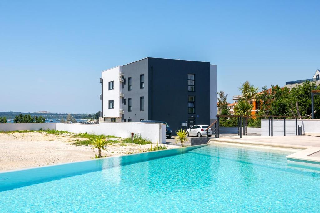 a swimming pool in front of a building at Vizula Sunset F - Noa & Aurelia Maris in Medulin