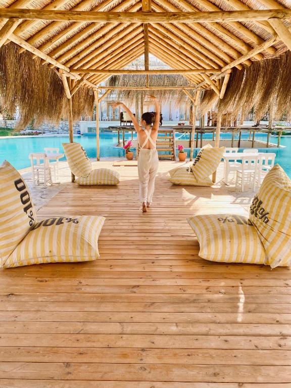 a woman walking on a wooden deck in a resort at Alaçatı Barbarossa Hotel in Çeşme