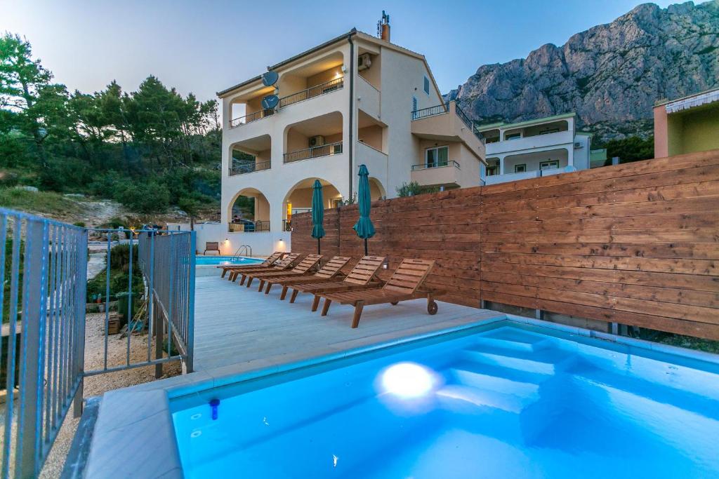 une villa avec une piscine et une maison dans l'établissement Apartments Fiona - away from city crowds, à Makarska