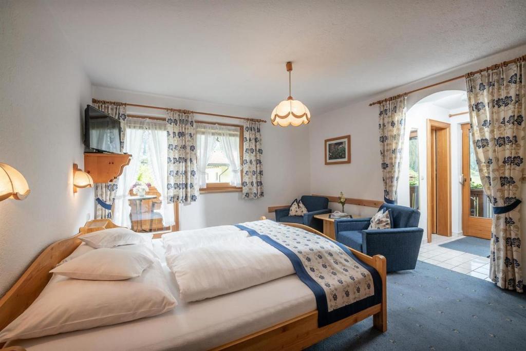 a bedroom with a bed and a living room at Gästeheim Auwitsch in Mayrhofen