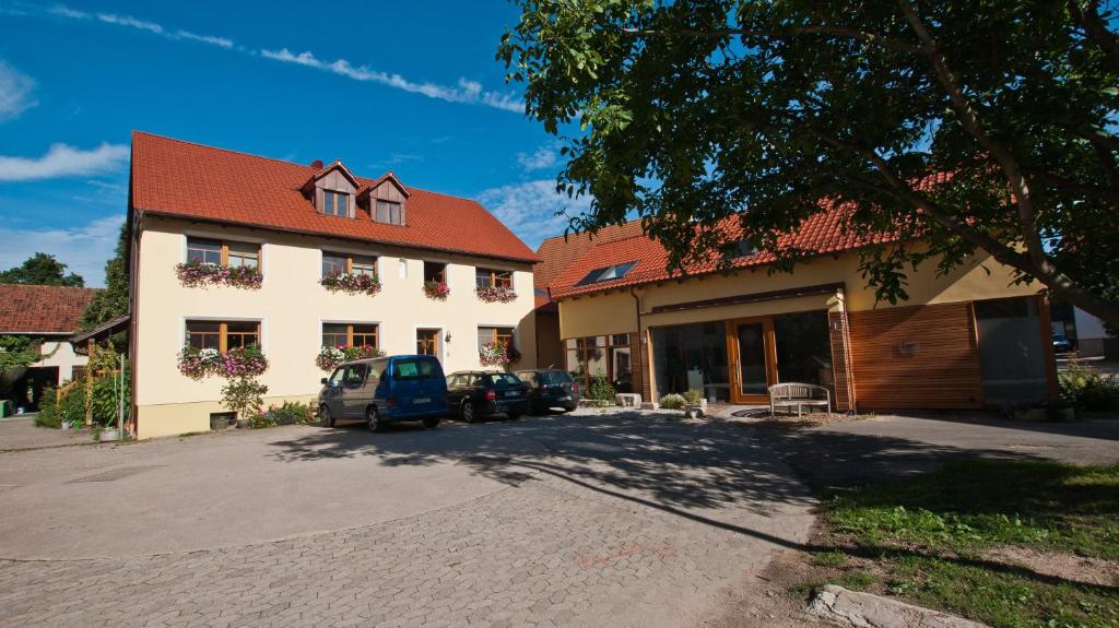 a building with cars parked in a parking lot at Haflingerhof Galster in Markt Taschendorf