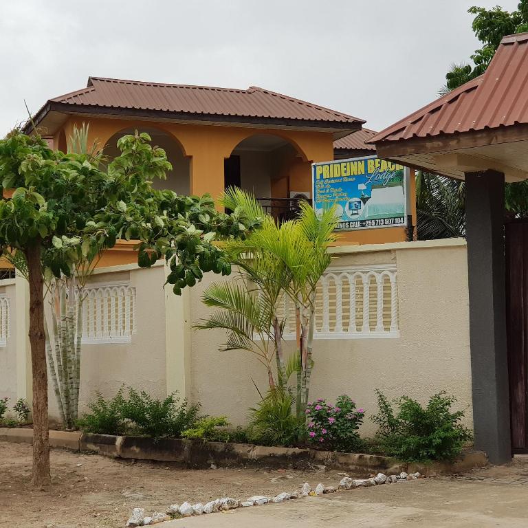 a house with a sign on the side of it at Prideinn Lodge Kigamboni in Dar es Salaam