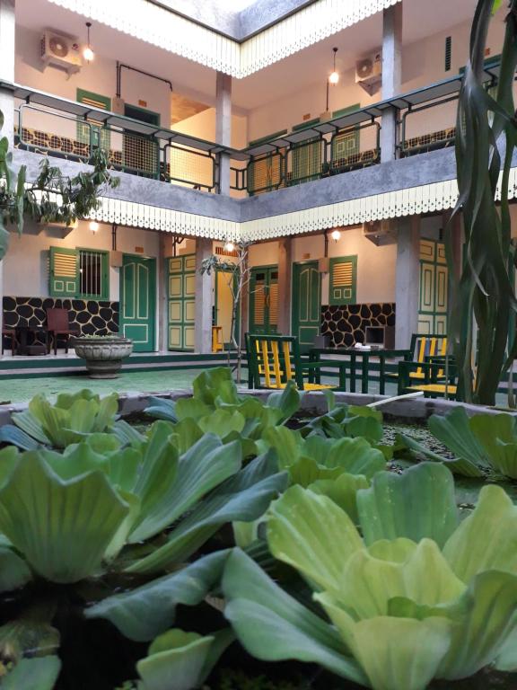 a courtyard of a building with large green plants at Joglo Aruna SYARIAH in Yogyakarta