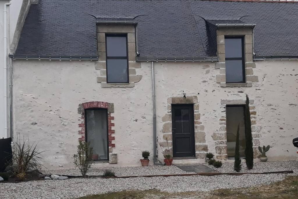 un edificio blanco con 4 ventanas y techo negro en TY FAROMA, en Sarzeau