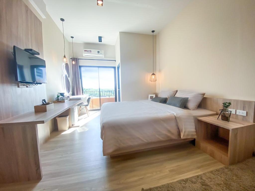 - une chambre avec un lit et un bureau dans l'établissement I-Home Residence and Hotel, à Pluak Daeng