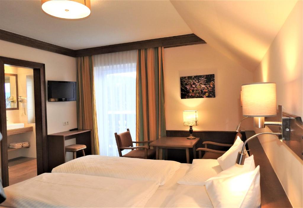 A bed or beds in a room at Hotel Stockerwirt