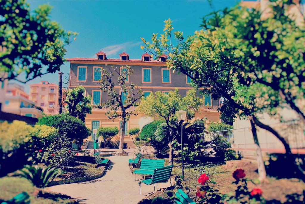 a building with a green bench in a garden at Hotel Villa Sophia in Sanremo