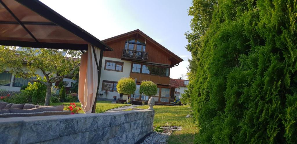 una casa es vista a través de un seto verde en Ferienwohnung Siglreitmaier en Chieming