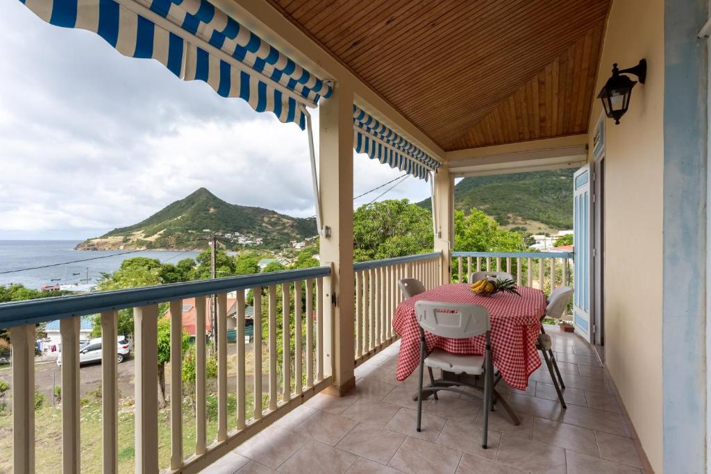uma varanda com mesa e cadeiras e vista para o oceano em Villa Yayanne em Les Anses-dʼArlets