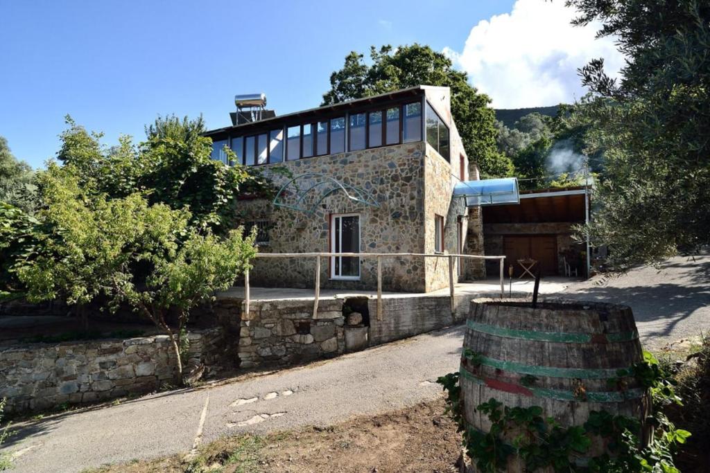 Kántanos的住宿－Villa Areti - A Cottage in the Cretan Nature，前面有桶的石头房子