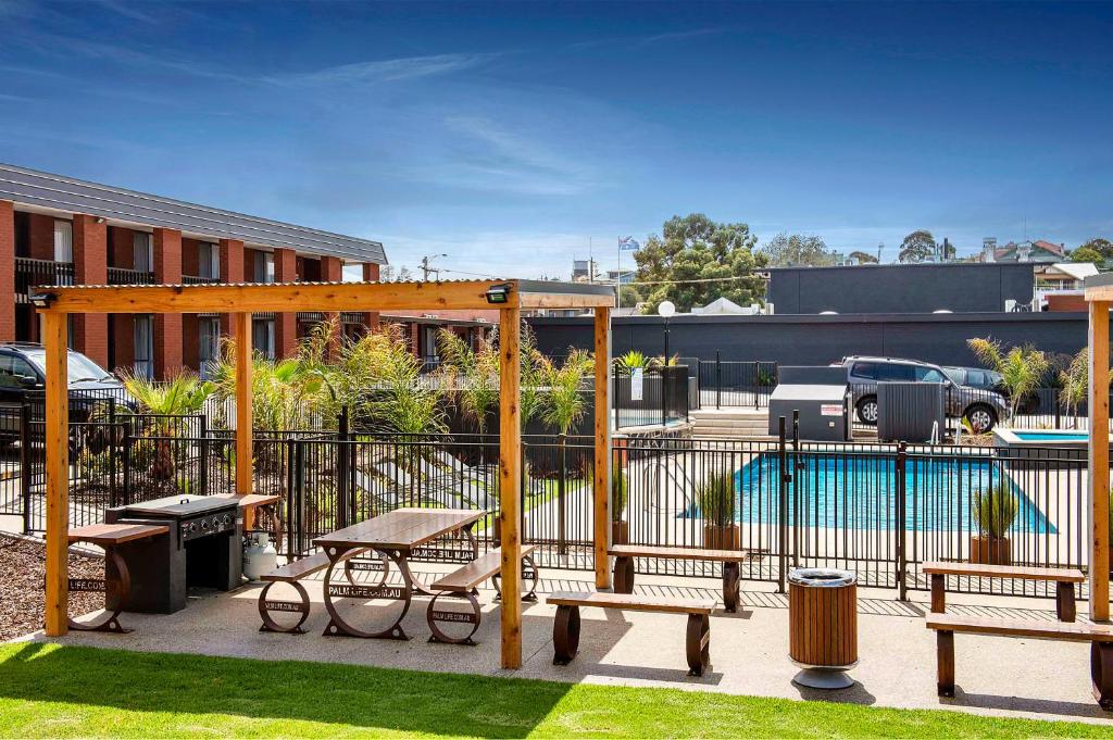 ウォーナンブールにあるMid City Motel Warrnamboolのベンチとフェンスのある公園