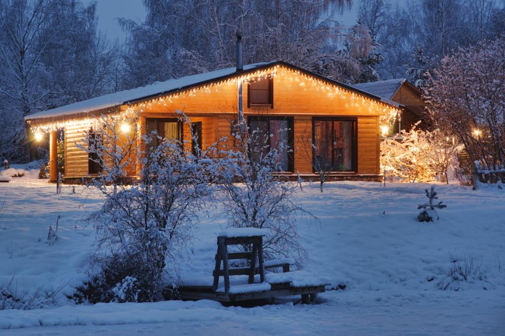 a log cabin in the snow with lights on it at Псковские дали in Pushkinskiye Gory