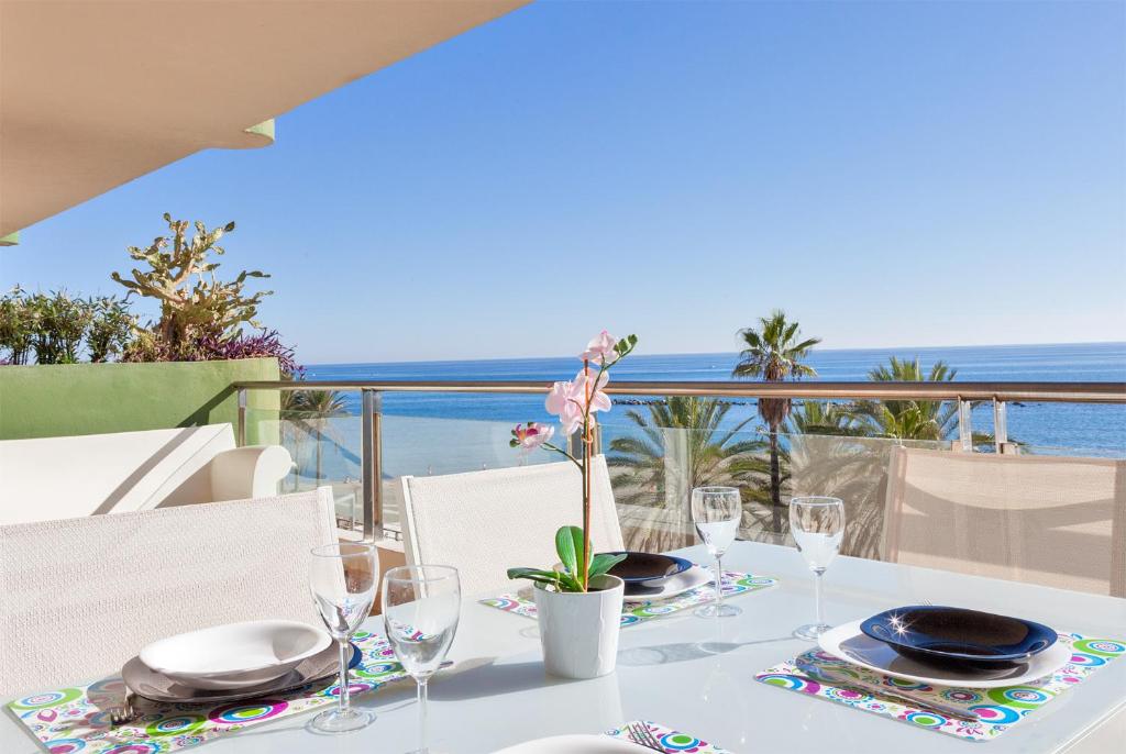 a table with plates and glasses and a view of the ocean at Apartamento SAN FERMIN in Benalmádena