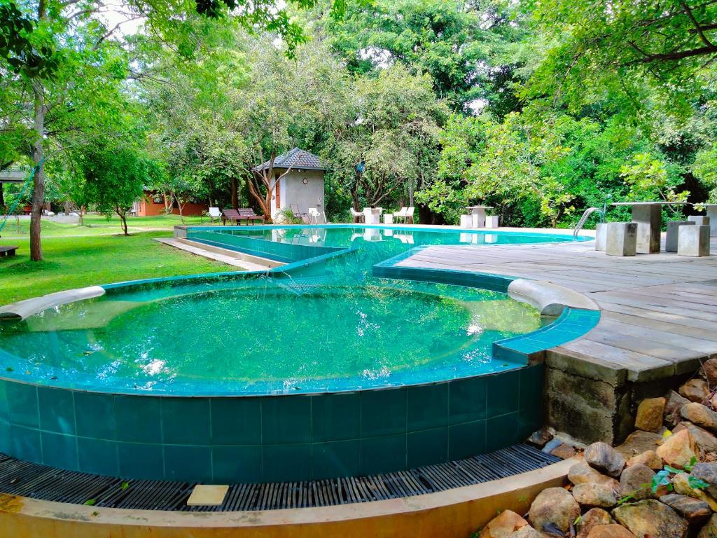 a large pool with a hot tub in a yard at Nil Diya Mankada Safari Lodge in Udawalawe