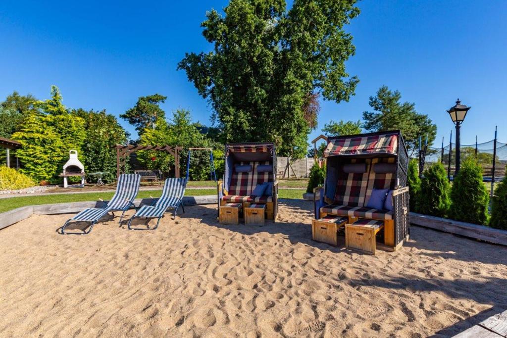 three chairs sitting in the sand in a park at Ferienanlage Seefeldt in Freest