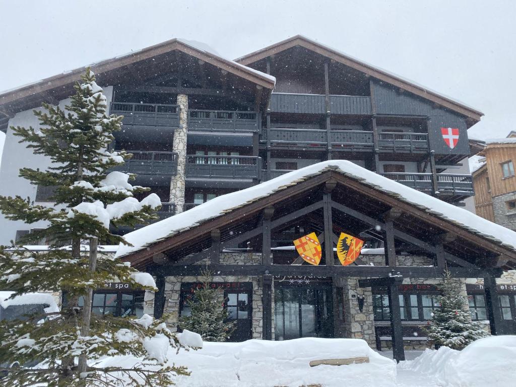 a large building with snow on top of it at La Savoyarde in Val-d'Isère