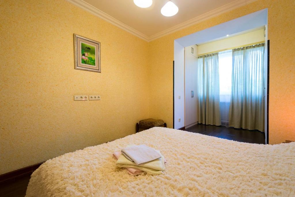 アルマトイにあるNadezhda Apartments in touristic area, on the Dostyk avenue 89の帽子が置かれたベッドのある寝室