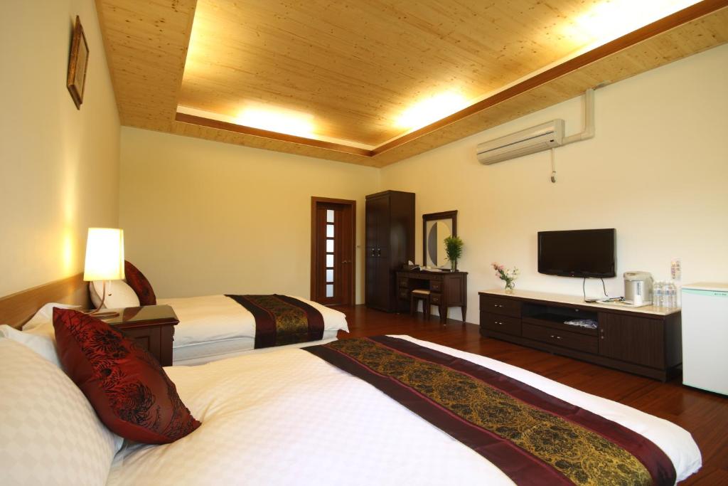 a hotel room with two beds and a flat screen tv at Countryside B&amp;B in Ruisui