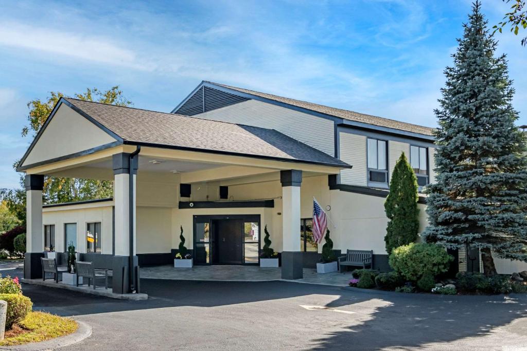 ein Haus mit einem Baum in der Einfahrt in der Unterkunft Clarion Inn in Nashua