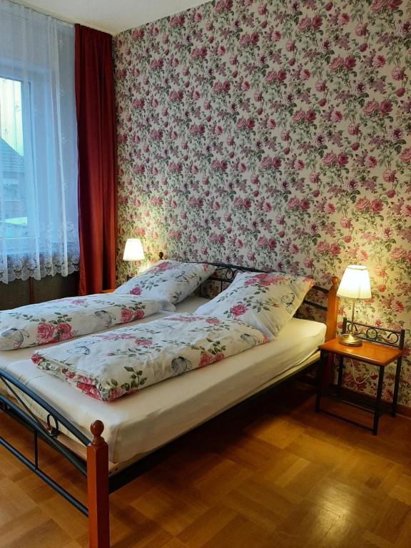 a bedroom with a bed with a floral wallpaper at barrierefreie Apartments in Kerken