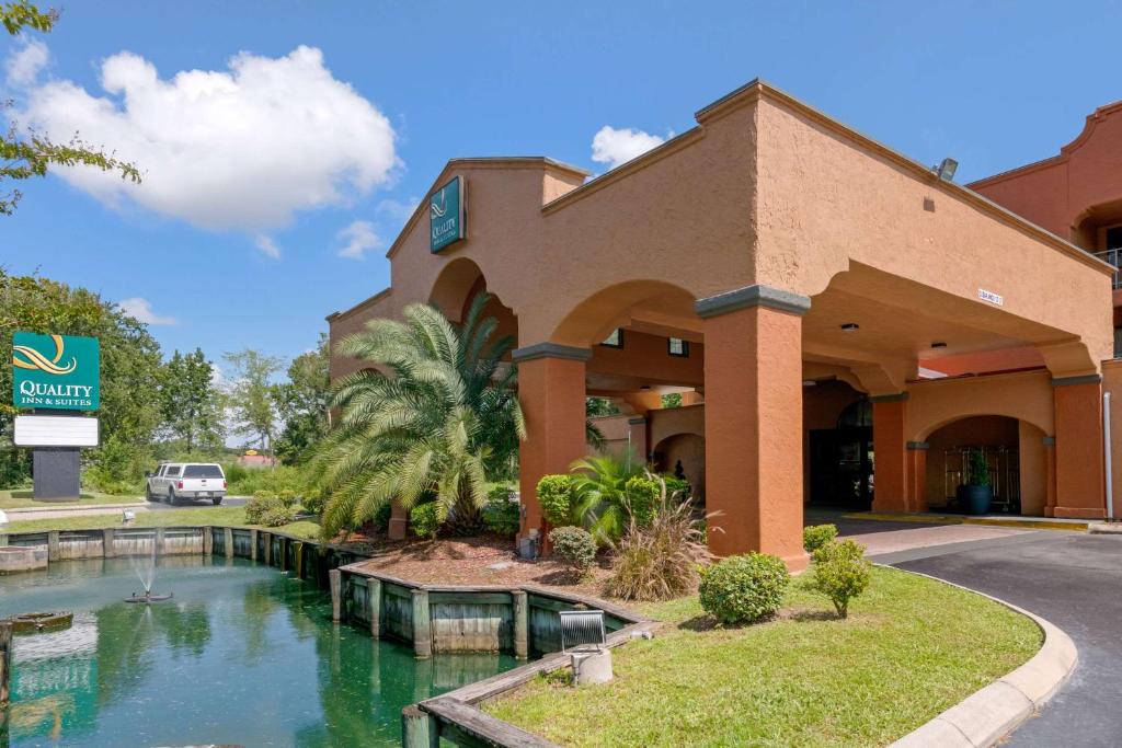 a hotel front of a building with a pool of water at Quality Inn & Suites Jacksonville-Baymeadows in Jacksonville