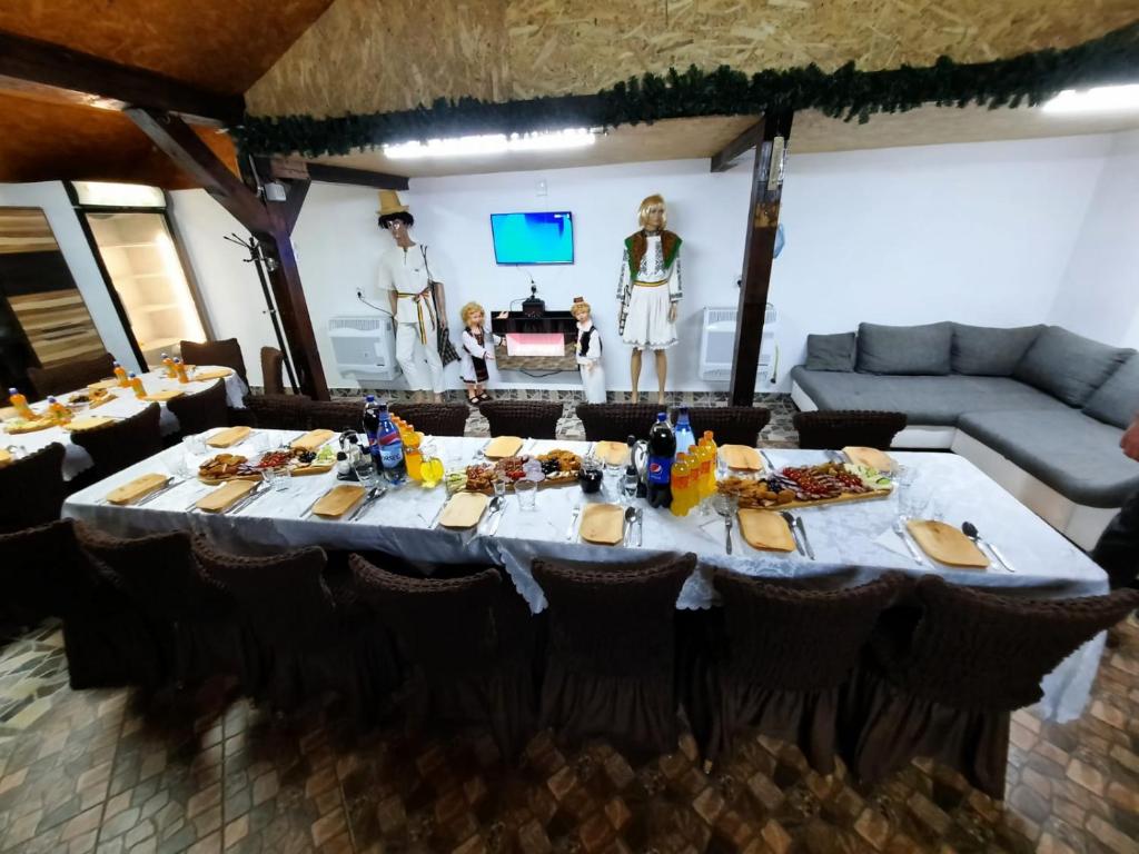 stolik w pokoju z ludźmi stojącymi w tle w obiekcie Pensiunea Raul w mieście Tăşnad