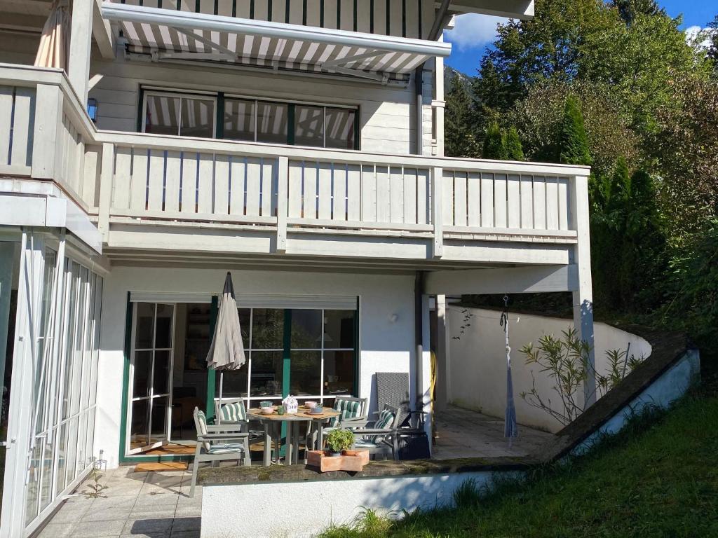 ein Haus mit einem Balkon mit einem Tisch und Stühlen in der Unterkunft Ferienwohnung am Burgberg in Marquartstein