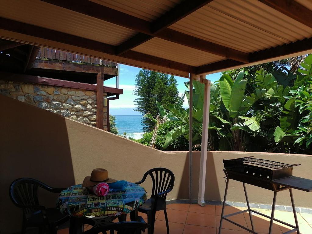 una mesa y sillas en un porche con vistas al océano en All the Tides - Between Tides, en Margate