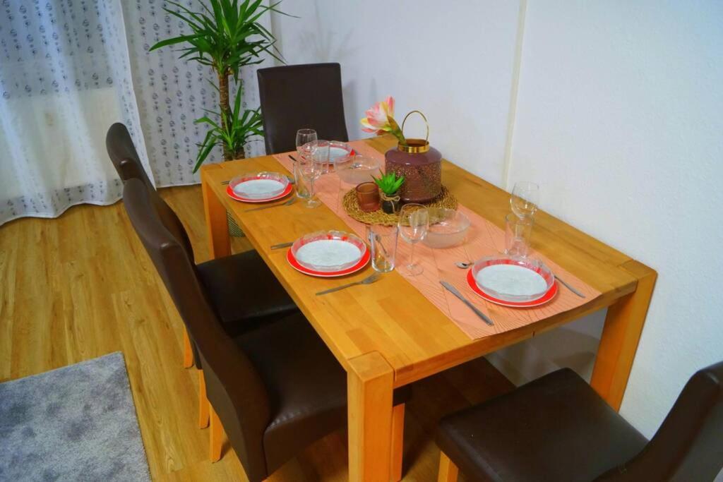 einen Holztisch mit Tellern und Weingläsern darauf in der Unterkunft Zentrum Speyer Premium-Apartment in Speyer