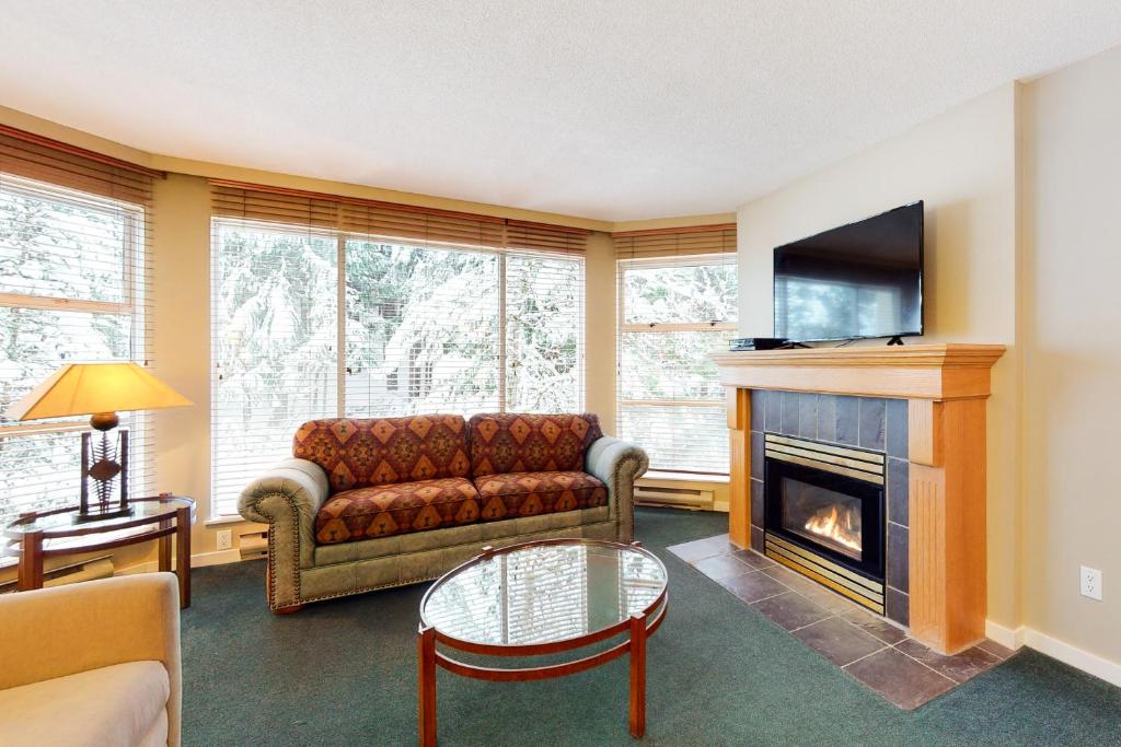 uma sala de estar com um sofá e uma lareira em Woodrun #418 em Whistler