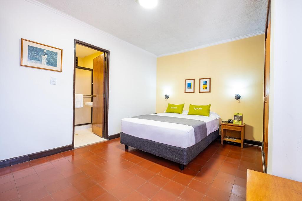 Habitación de hotel con cama y espejo en Ayenda 1502 Principe, en Bucaramanga