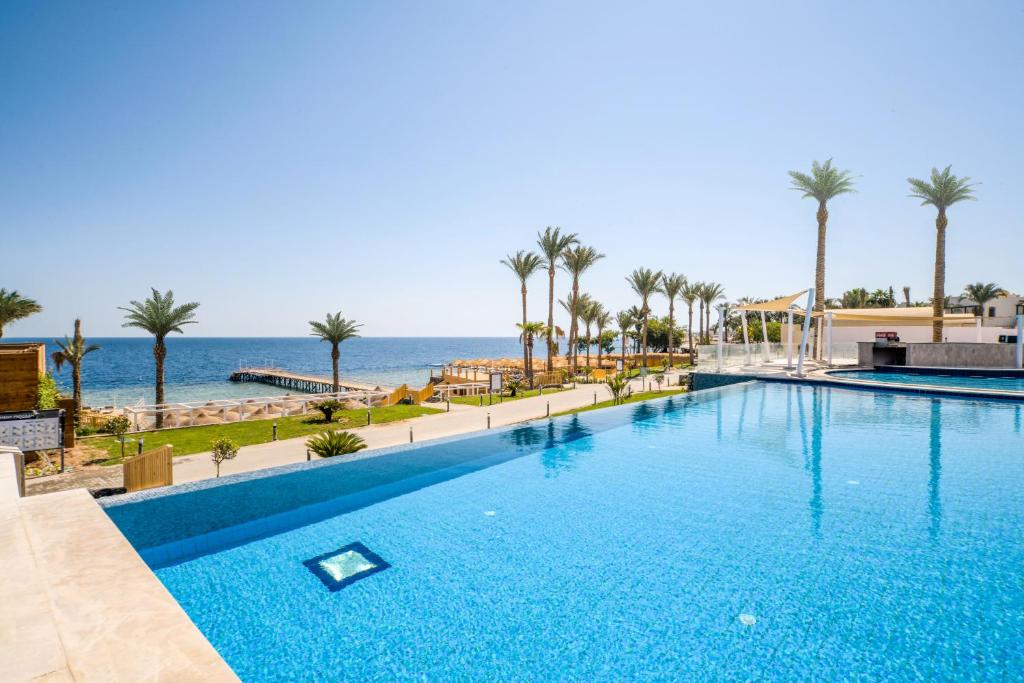 a swimming pool with the ocean in the background at Sunrise Diamond Beach Resort -Grand Select in Sharm El Sheikh