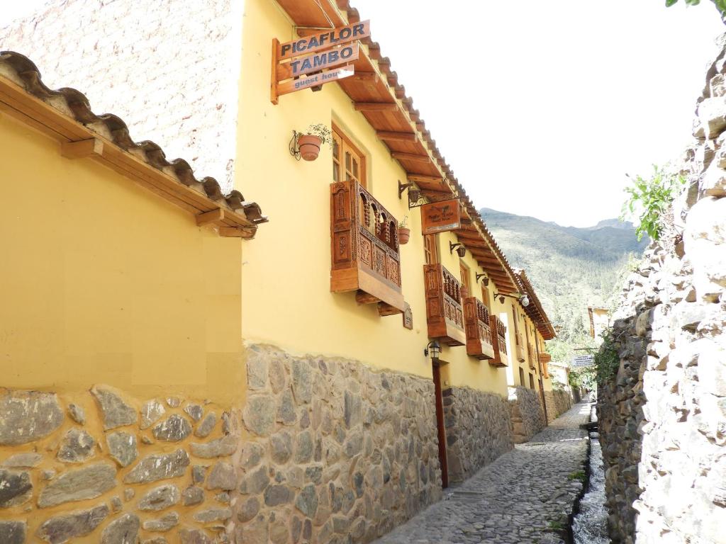een steegje met een stenen muur en een gebouw bij Picaflor Tambo Guest House in Ollantaytambo