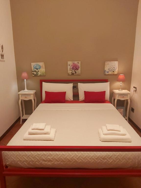 a bedroom with a large bed with red pillows at LODGING 5 TERRE & PORTO LA SPEZIA in La Spezia
