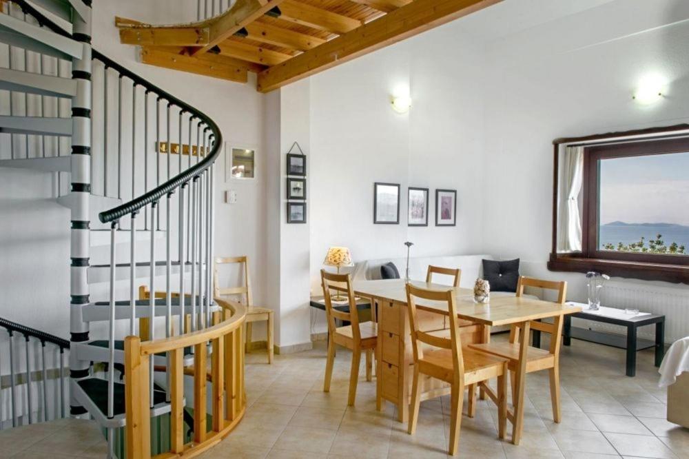 jadalnia ze stołem i spiralnymi schodami w obiekcie Katevi Luxury Seafront Villa w mieście Ierissós