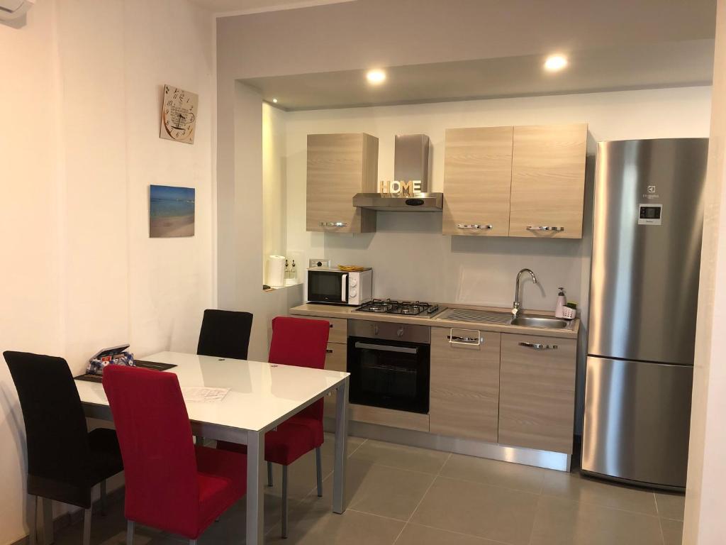 a kitchen with a table and a stainless steel refrigerator at DeA del Salento in Lecce