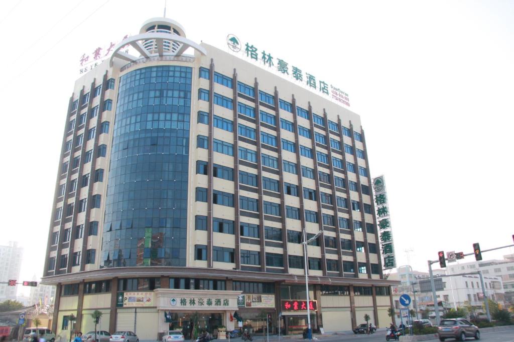 a large glass building on a city street at GreenTree Inn Guangdong Shantou Chengjiang Road Business Hotel in Shantou