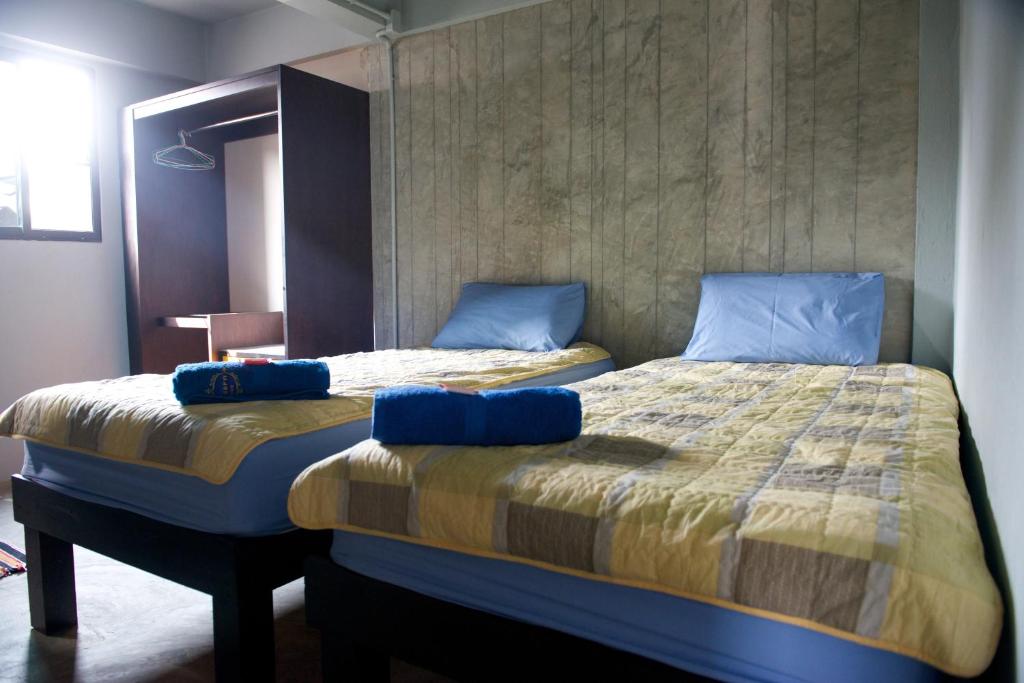 1 dormitorio con 2 camas con almohadas azules en 9 Hostel, en Chiang Mai