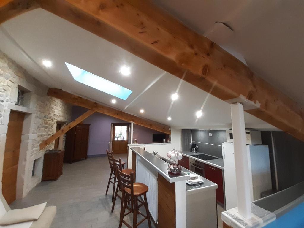 a kitchen with a vaulted ceiling and a kitchen with chairs at GITES LES MAISONS ROUGES in Jasseron