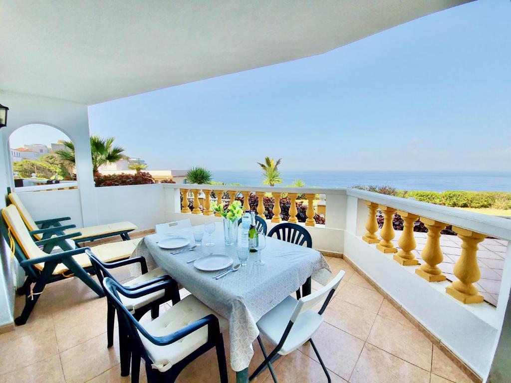 a dining room with a table and chairs and the ocean at Apartamento Mar in Puerto de la Cruz