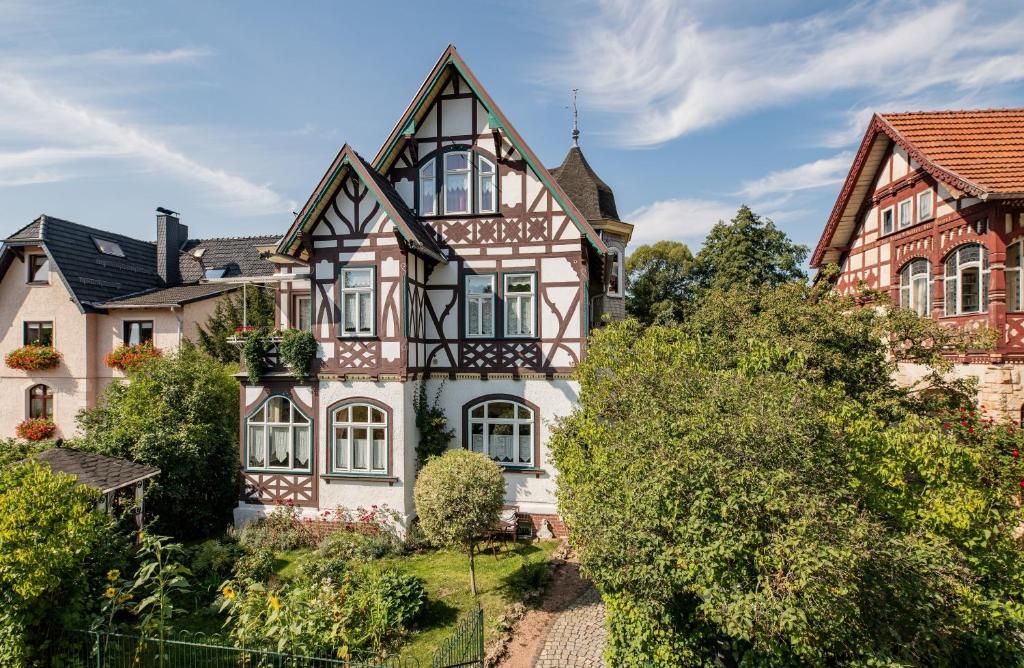 an old house in a village with trees at Hotel Villa Rossek in Bad Liebenstein