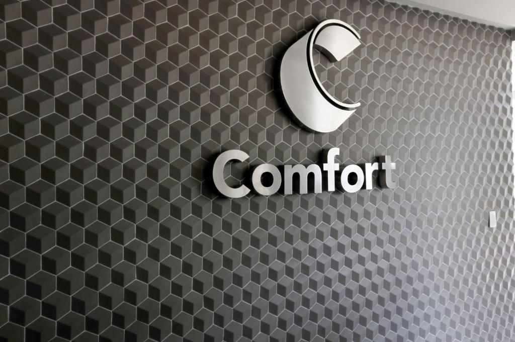 a cnet sign on a wall with a honeycomb pattern at Comfort Hotel Guarulhos Aeroporto in Guarulhos