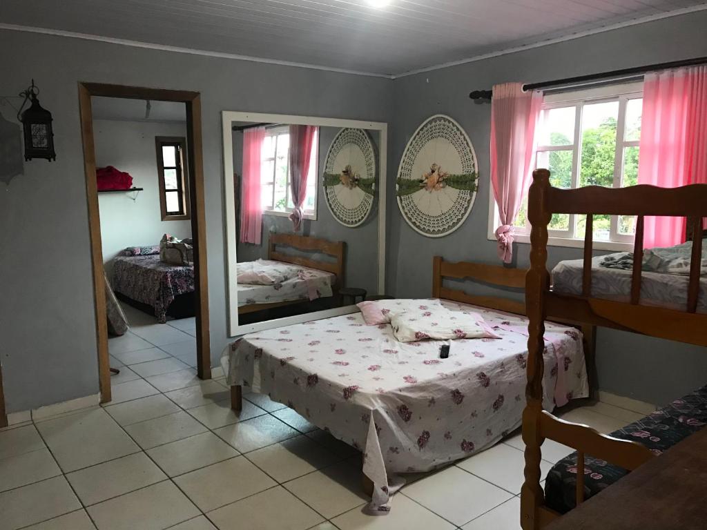 a bedroom with a bed and a mirror at Residencial Segundo Piso in Garopaba